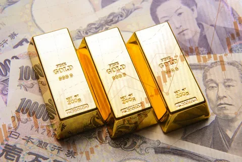 Gold bullion bars alongside Japanese yen currency and cryptocurrency charts